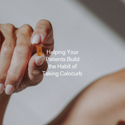 Close-up of a hand holding a Calocurb capsule, representing patient habit-building and daily supplement routines